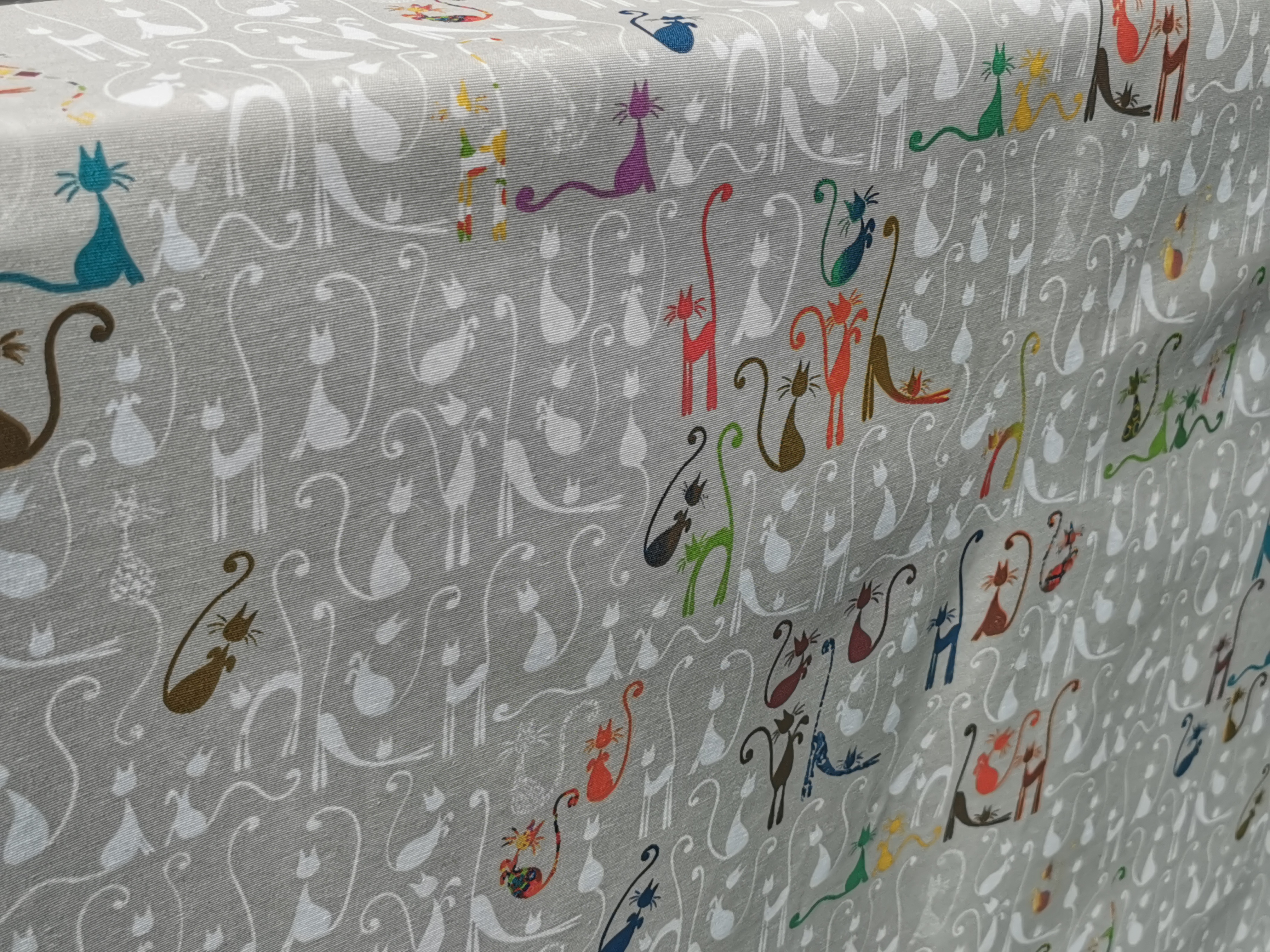 Beschichteter Baumwollstoff "Beige mit weißen und bunten Katzen" (Breite 140 cm x Länge wählbar in 50 cm Schritten)